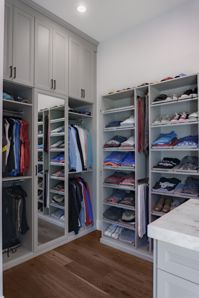 Photo of a Men&#039;s Master closet with this dress shirts nicely folded and hung with a mirrored door