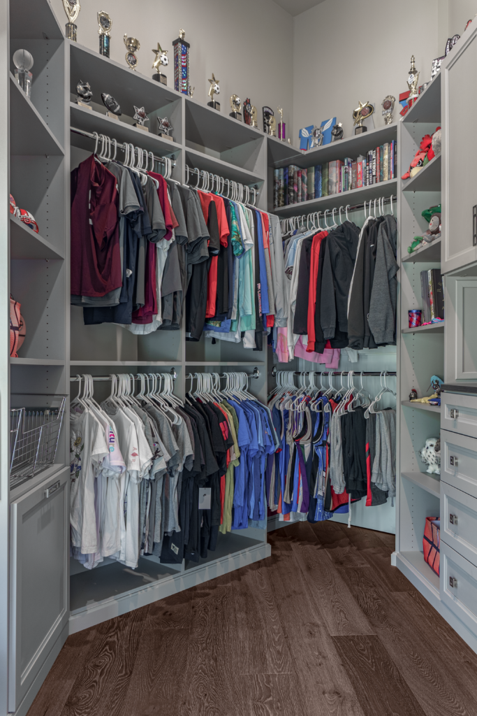 Photo of a boys closet with clothes hung